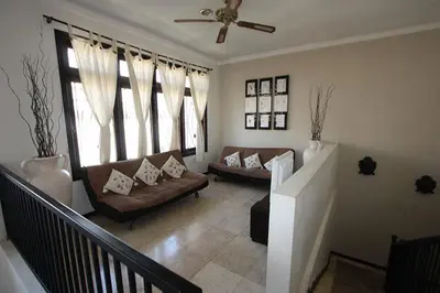 a living room with two couches and a ceiling fan at Villa Indah Kuta Royal - Private Pool - Optic Fiber High Speed Internet in Kuta