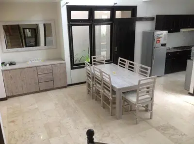a kitchen with a table and chairs and a refrigerator at Villa Indah Kuta Royal - Private Pool - Optic Fiber High Speed Internet in Kuta