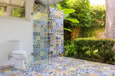 a bathroom with a toilet and a tiled shower at Chanteak Bali in Jimbaran