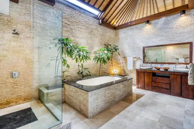 a bathroom with a tub and a sink and a mirror at Modern Private Villa Atala with Private XL Pool in Seminyak