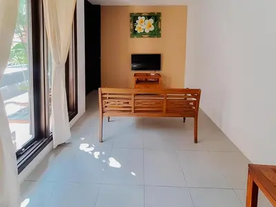 a living room with a television and a tiled floor at The Lavana Arimanu Kuta in Kuta