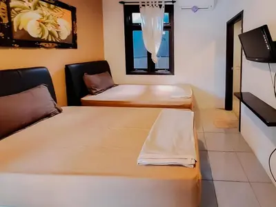 a room with two beds and a window at The Lavana Arimanu Kuta in Kuta