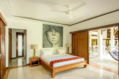 a bedroom with a bed and a painting on the wall at Villa Maharaj in Seminyak
