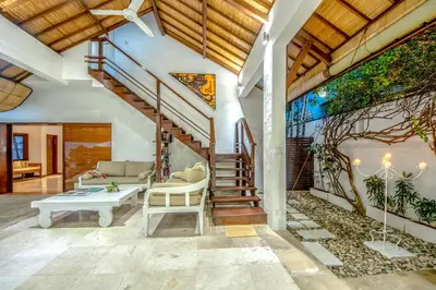 a living room with a staircase and a couch at Villa Maharaj in Seminyak