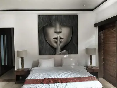 a painting of a woman with her finger in her mouth at Villa Maharaj in Seminyak