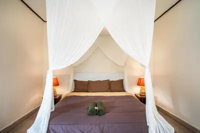 a bedroom with a bed with a canopy at Villa Janitra in Seminyak