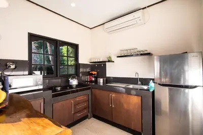 a large kitchen with a stainless steel refrigerator at Villa Janitra in Seminyak