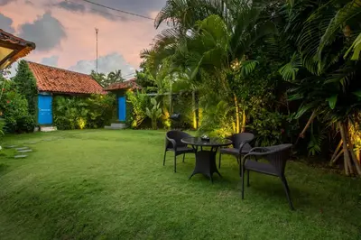 a patio with chairs and a table in a yard at Villa Janitra in Seminyak