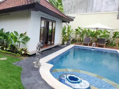 a swimming pool in front of a house at Tegal Uma Seminyak by Maha Bali in Seminyak