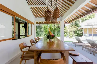 a dining room with a wooden table and chairs at Villa Senan in Seminyak