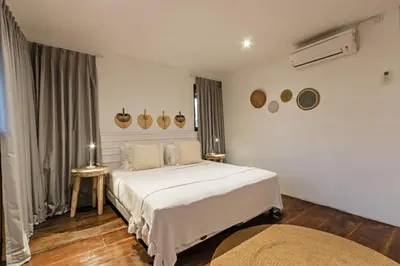 a white bedroom with two beds and a window at Villa Senan in Seminyak
