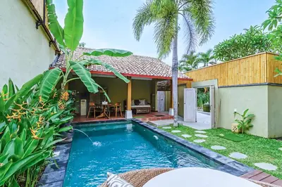 a villa with a swimming pool and a house at Villa Senan in Seminyak