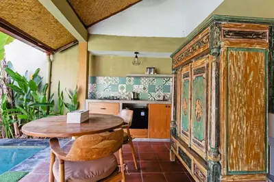 an old wooden cabinet in a kitchen with a table at Villa Senan in Seminyak