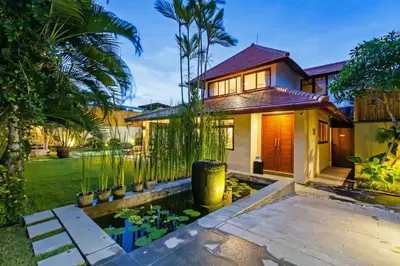 a house with a pond in front of it at Villa Senan in Seminyak