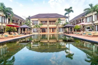a swimming pool in front of a building at Vidi Boutique Hotel in Nusa Dua