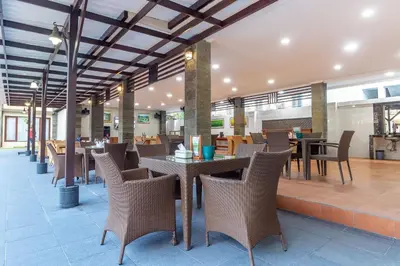 a restaurant with tables and chairs in a building at Vidi Boutique Hotel in Nusa Dua