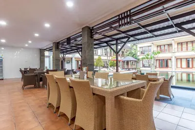 a dining room with tables and chairs in a building at Vidi Boutique Hotel in Nusa Dua