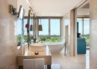 a bathroom with a tub and a large window at RIMBA by AYANA Bali in Jimbaran
