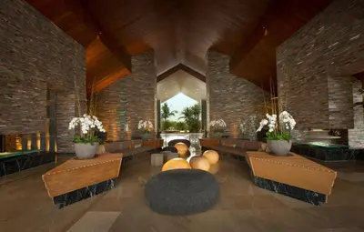 a lobby with couches and chairs and a fireplace at RIMBA by AYANA Bali in Jimbaran