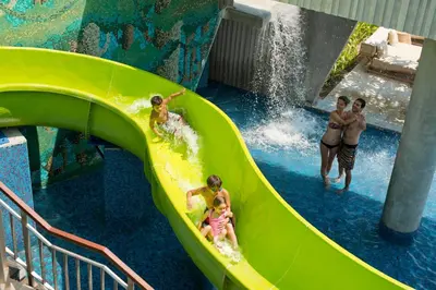 a group of children on a water slide at a water park at RIMBA by AYANA Bali in Jimbaran