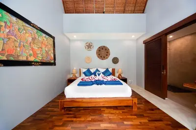 a bedroom with a bed and a large painting on the wall at Kusuma Living and Villa Seminyak in Seminyak