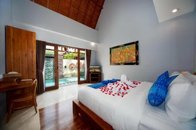 a bedroom with a bed and a desk and a television at Kusuma Living and Villa Seminyak in Seminyak