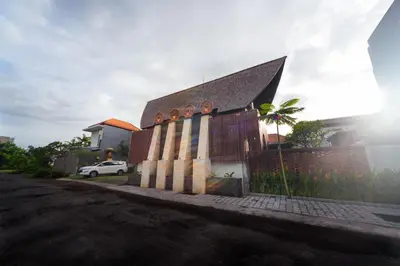 a church with a building with the sun behind it at Kusuma Living and Villa Seminyak in Seminyak