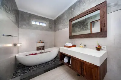 a bathroom with a tub and a sink and a mirror at Kusuma Living and Villa Seminyak in Seminyak
