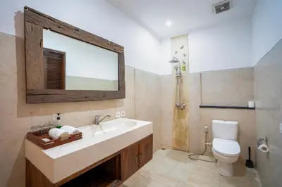 a bathroom with a sink and a toilet and a mirror at Kusuma Living and Villa Seminyak in Seminyak