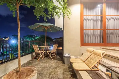 a patio with a table and chairs and an umbrella at The jero 18 kuta guest house in Kuta