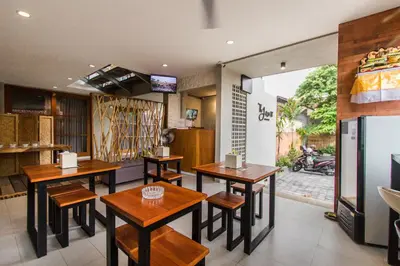 a restaurant with tables and chairs in a room at The jero 18 kuta guest house in Kuta