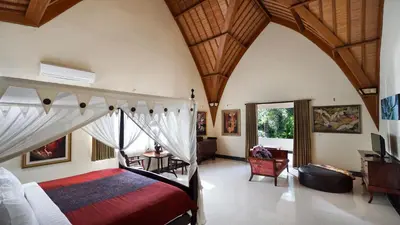 a bedroom with a canopy bed and a living room at Villa Bali Maja - Beautiful Private Pool Villa in Petitenget, Seminyak in Seminyak
