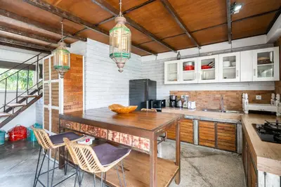 a kitchen with a wooden table and chairs at Lolo #2 Apartment by Betterplace in Canggu