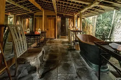 an old room with a bath tub and a chair at Villa Jasli in Canggu