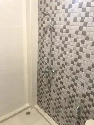 a bathroom with a shower with a glass door at Simple Kuta Bedroom in Kuta