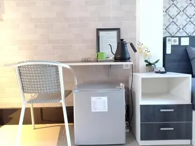 a desk with a chair next to a refrigerator at Simple Kuta Bedroom in Kuta