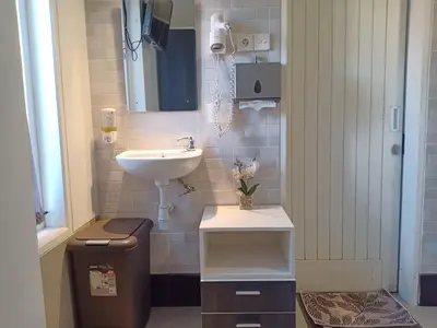 a small bathroom with a sink and a mirror at Simple Kuta Bedroom in Kuta