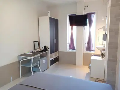 a room with a bed and a desk and a sink at Simple Kuta Bedroom in Kuta