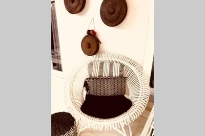 a white wicker chair with a pillow and a clock at Villa Bloom 4 - 2 King bedrooms , Sleep 4 Pax, private pool, Seminyak in Seminyak