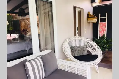a porch with a wicker chair and a couch at Villa Bloom 4 - 2 King bedrooms , Sleep 4 Pax, private pool, Seminyak in Seminyak