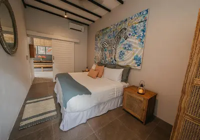 a bedroom with a bed and a painting on the wall at Villa Bloom 5 close to the beach private pool 3 bedrooms 3 bathrooms in Seminyak