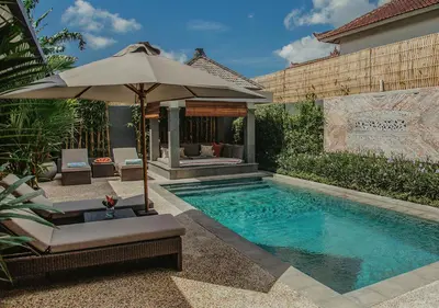a swimming pool with an umbrella and chairs and an umbrella at Villa Bloom 5 close to the beach private pool 3 bedrooms 3 bathrooms in Seminyak