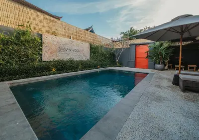 a swimming pool in a backyard with an umbrella at Villa Bloom 5 close to the beach private pool 3 bedrooms 3 bathrooms in Seminyak
