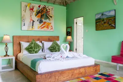 a bedroom with a bed in a room with green walls at Villa Noretsy in Seminyak