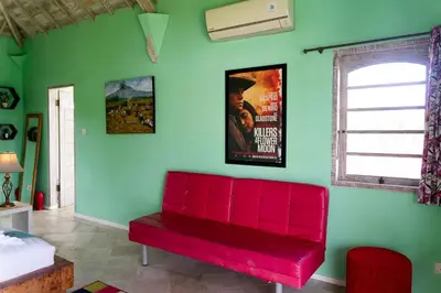 a red bench in a room with a green wall at Villa Noretsy in Seminyak