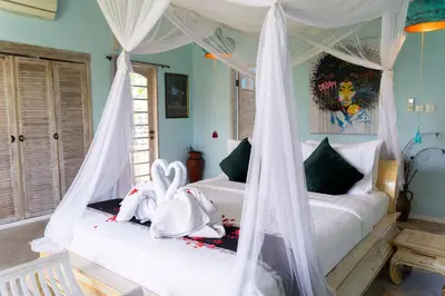 a bedroom with two beds with white drapes at Villa Noretsy in Seminyak