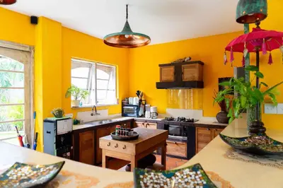 a large kitchen with yellow walls and a table at Villa Noretsy in Seminyak