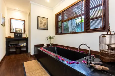 a kitchen with a sink with flowers on the counter at Mango Tree Villas Jimbaran Bali in Jimbaran