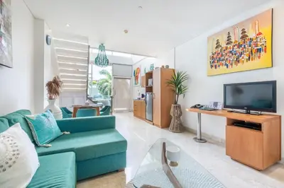 a living room with a blue couch and a tv at AQ-VA Hotel & Villas Seminyak in Legian