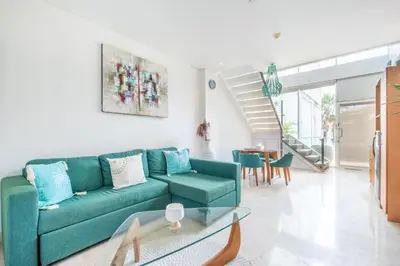 a living room with a green couch and a table at AQ-VA Hotel & Villas Seminyak in Legian
